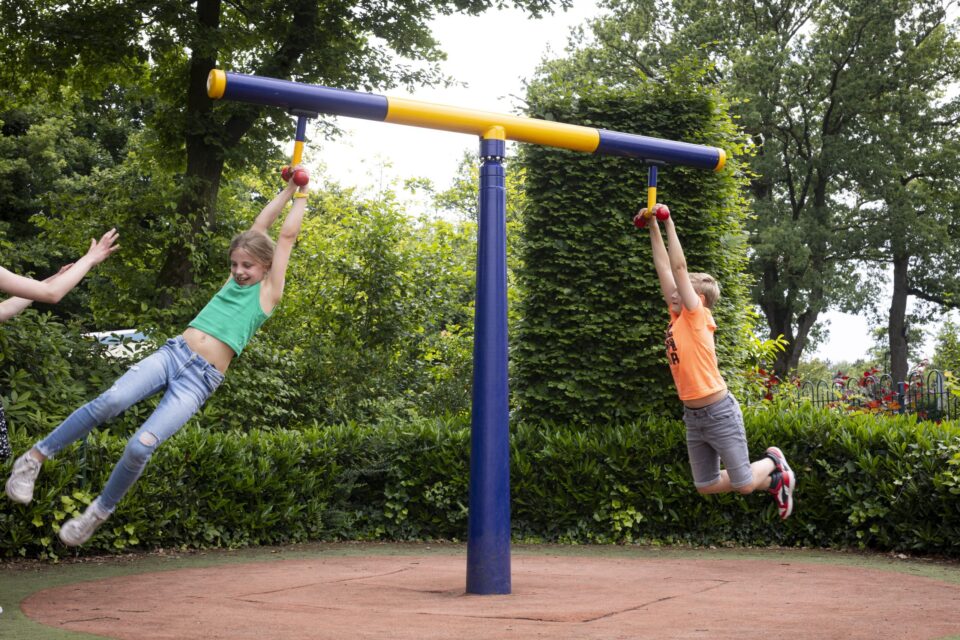 Kinderen hangen aan draaitoestel speeltuin bij Hotel Havezate Marveld