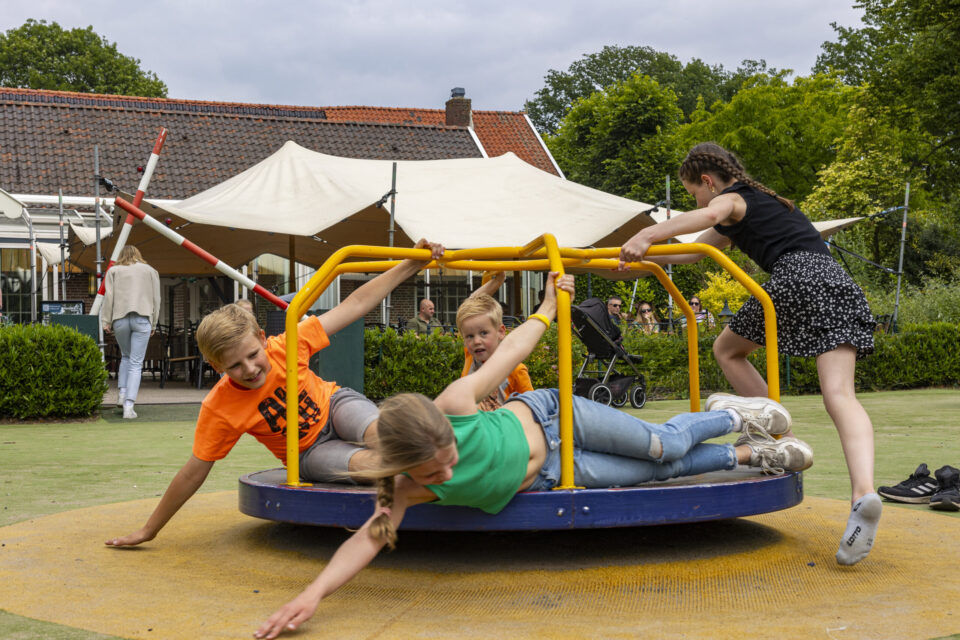 Kinderen op draaitoestel in speeltuin bij Hotel Havezate Marveld